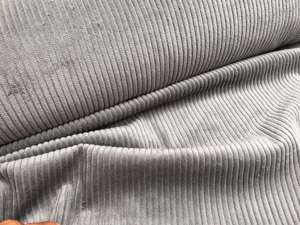 Fastvævet - bred riflet fløjl i mellem grå, solskadet på fold. Restestykke på 1,5 m